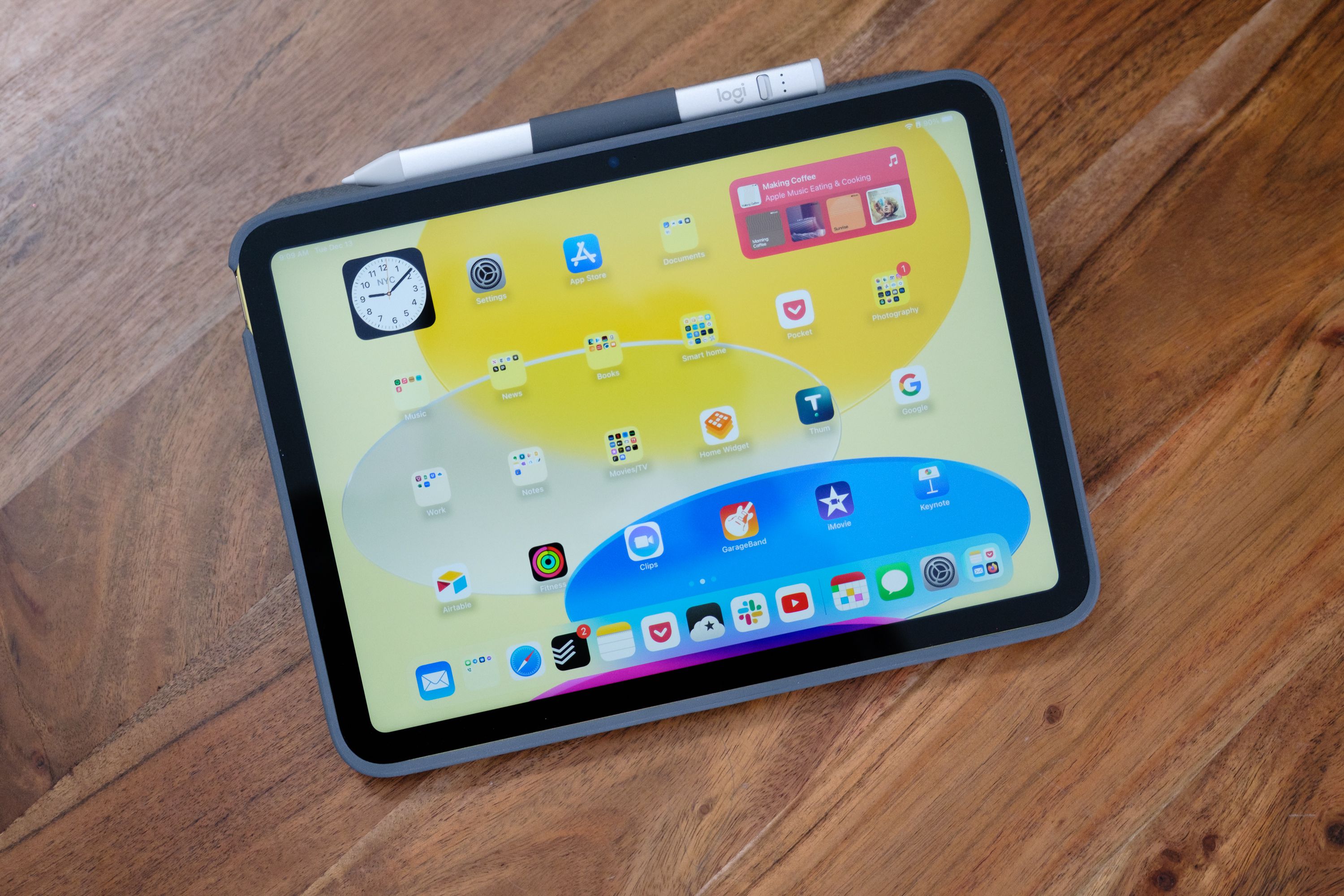 A 10th Gen Apple iPad in a Logitech Combo Touch case on a wood table, viewed from the top down.