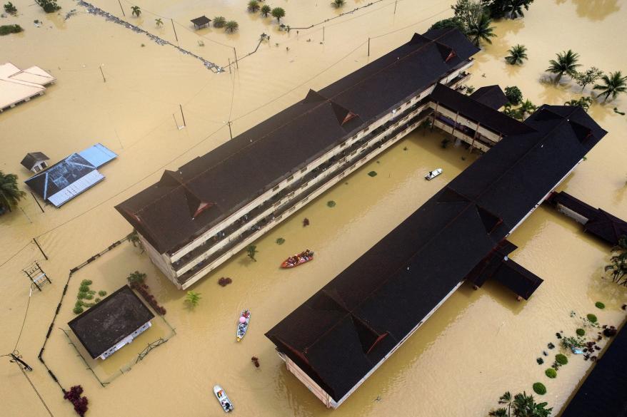Residents are rescued by boats from the flood relief centre as the flood water rise and partially submerged the building at Dungun, Terengganu, Malaysia on Dec. 21, 2022.