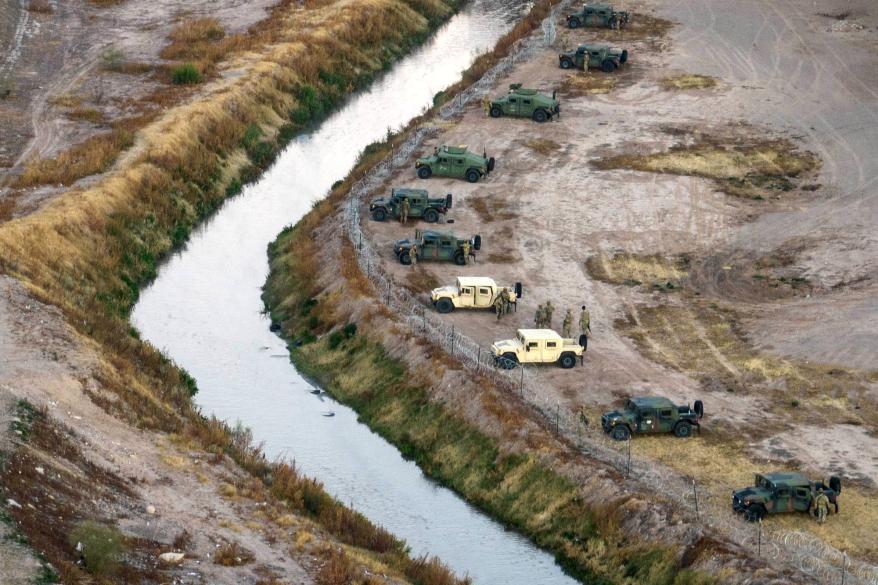 A line of armored vehicles also waited at the ready on the banks of the Rio Grande in El Paso, Texas.