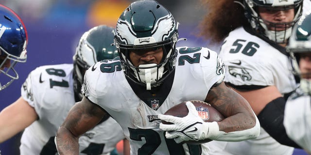 Miles Sanders #26 of the Philadelphia Eagles runs with the ball during the first half of the game against the New York Giants at MetLife Stadium on December 11, 2022 in East Rutherford, New Jersey.