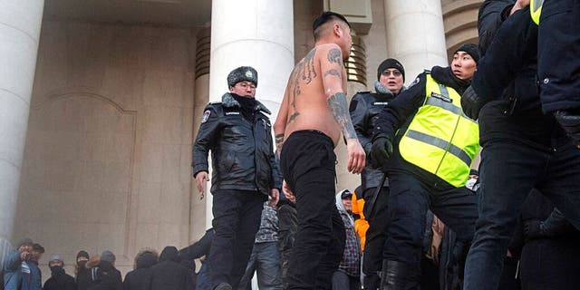 Security personnel react to protesters near the State Palace on Sukhbaatar Square in Ulaanbaatar in Mongolia on Monday, Dec. 5, 2022. 