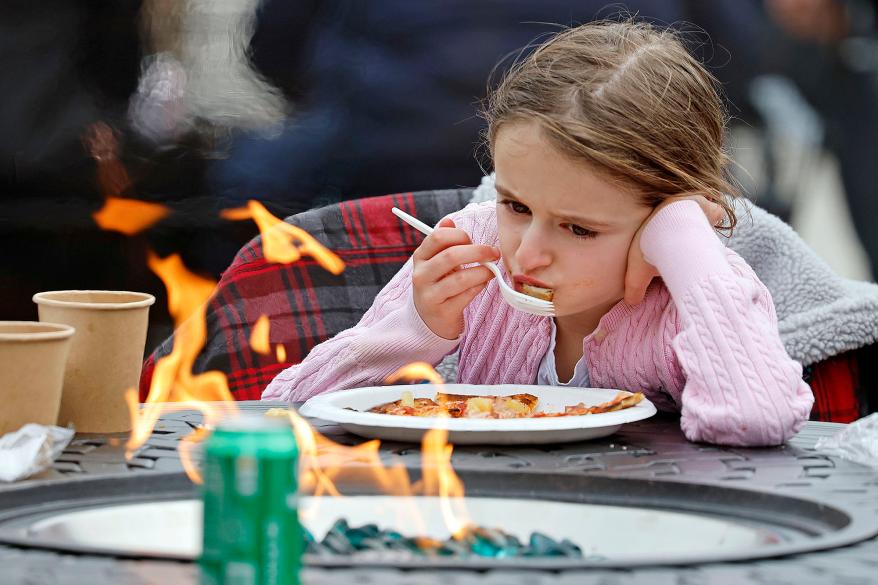 A picture of a young girl eating lunch with her family while the power is out.