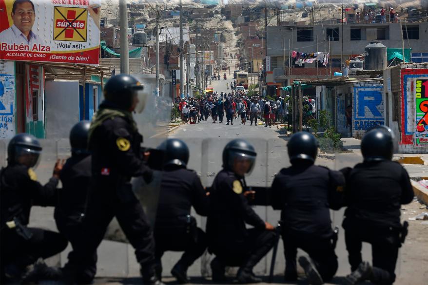 Riot police and supporters of ousted Peruvian President Pedro Castillo face off on the Pan-American North Highway, in Chao, Peru.