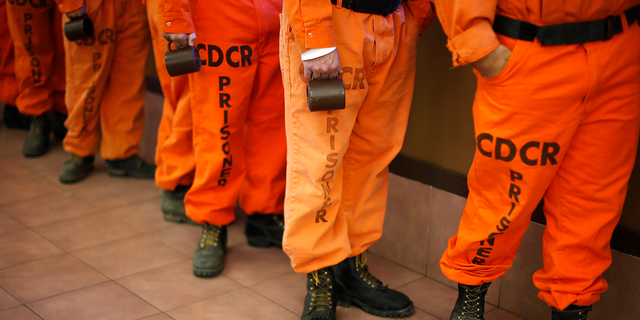 Prison inmates wearing firefighting boots line up for breakfast at Oak Glen Conservation Fire Camp #35 in Yucaipa, California 