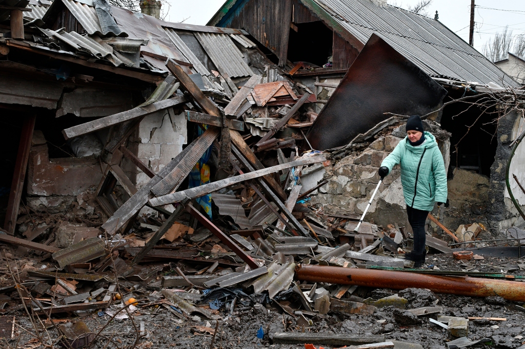 A woman stands near debris of her house following Wednesday's Russian shelling in Kurakhove, Donetsk region, Thursday. 