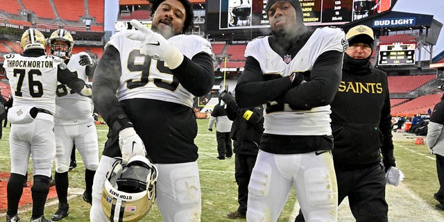 Shy Tuttle #99 and Paulson Adebo #29 of the New Orleans Saints pose for a photo after a win over the Cleveland Browns at FirstEnergy Stadium on December 24, 2022 in Cleveland, Ohio. 