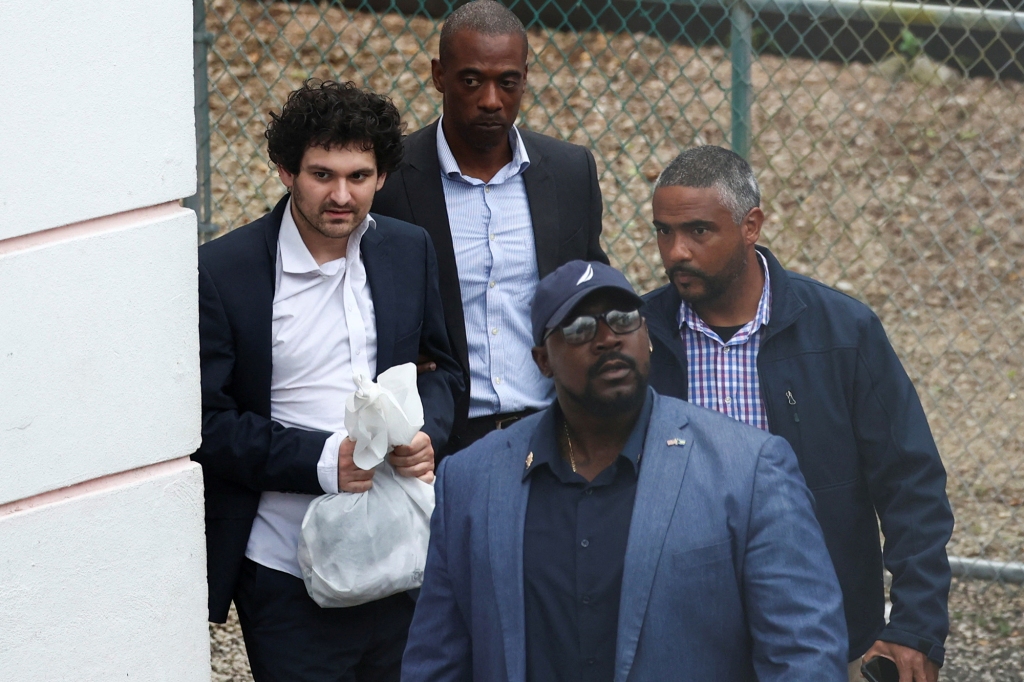 Sam Bankman-Fried, the founder and former CEO of crypto currency exchange FTX, is escorted out of the Magistrate Court building in Nassau, Bahamas, December 