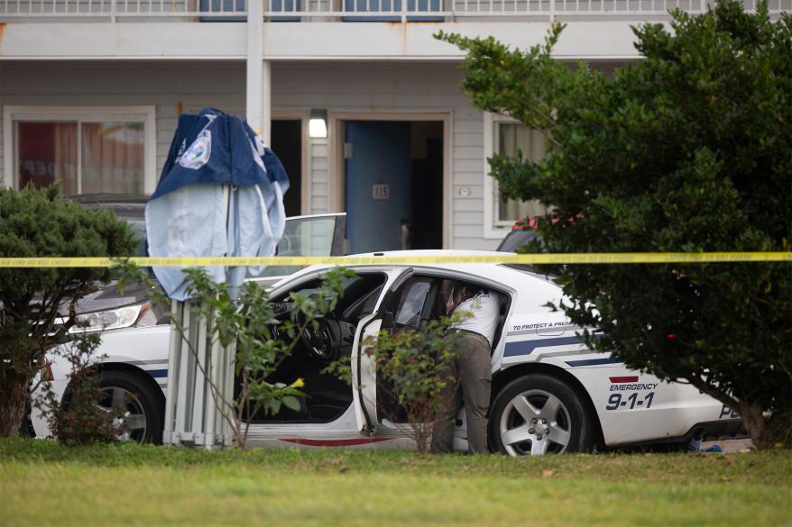 Law enforcement personnel work at the scene after two Bay St. Louis, Miss., police officers were shot and killed while responding to a call at a Motel 6, Wednesday, Dec. 14, 2022. Authorities say two police officers in coastal Mississippi were shot and killed by a woman who they had talked to for nearly 30 minutes early Wednesday in the motel parking lot. (Hannah Ruhoff/The Sun Herald via AP)