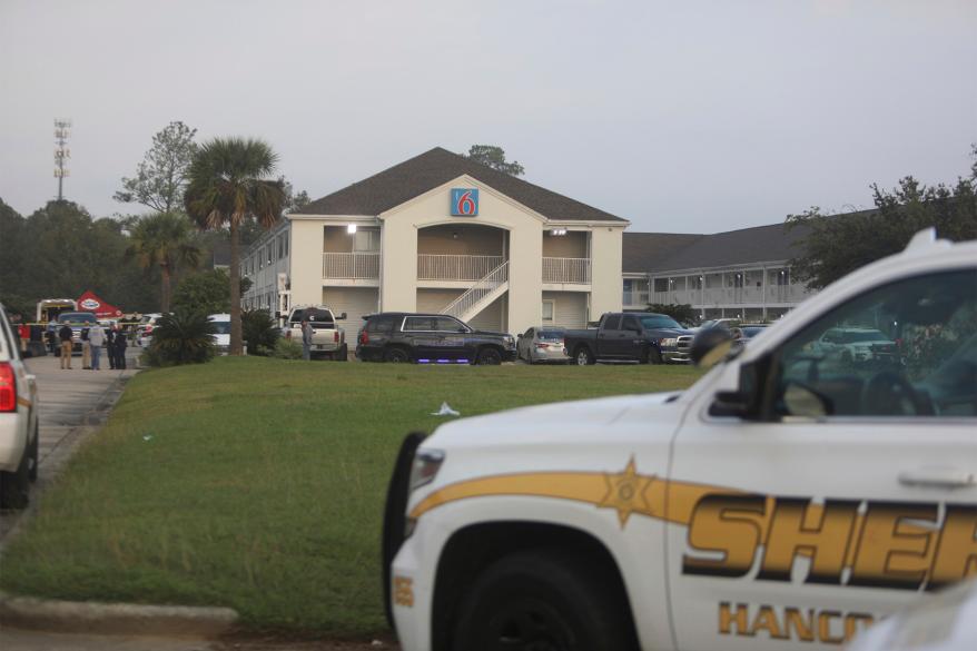 Law enforcement officials investigate the Motel 6 where two Bay St. Louis, Miss., police officers were killed in a shooting on Wednesday, Dec. 14, 2022. Officers encountered a female subject, who shot both officers before killing herself, the Mississippi Bureau of Investigation said. (Justin Mitchell/The Sun Herald, via AP)