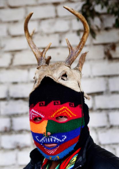 masked fighter Daniel Flores poses for a portrait before taking part in a Takanakuy .