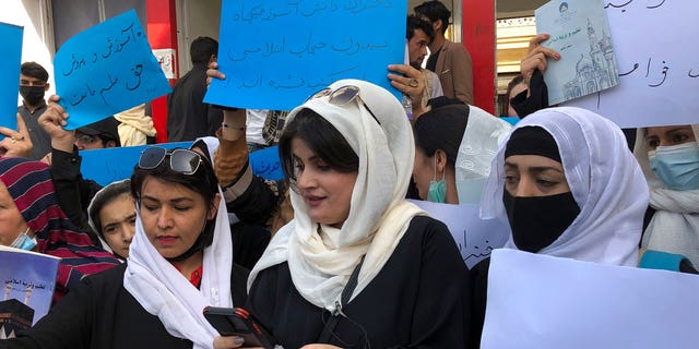 Afghan women chant and hold signs to protest during a demonstration in Kabul, Afghanistan, Saturday, March 26, 2022. Afghanistan's Taliban rulers refused to allow dozens of women to board several flights, including some overseas, because they were traveling without a male guardian, two Afghan airline officials said Saturday.