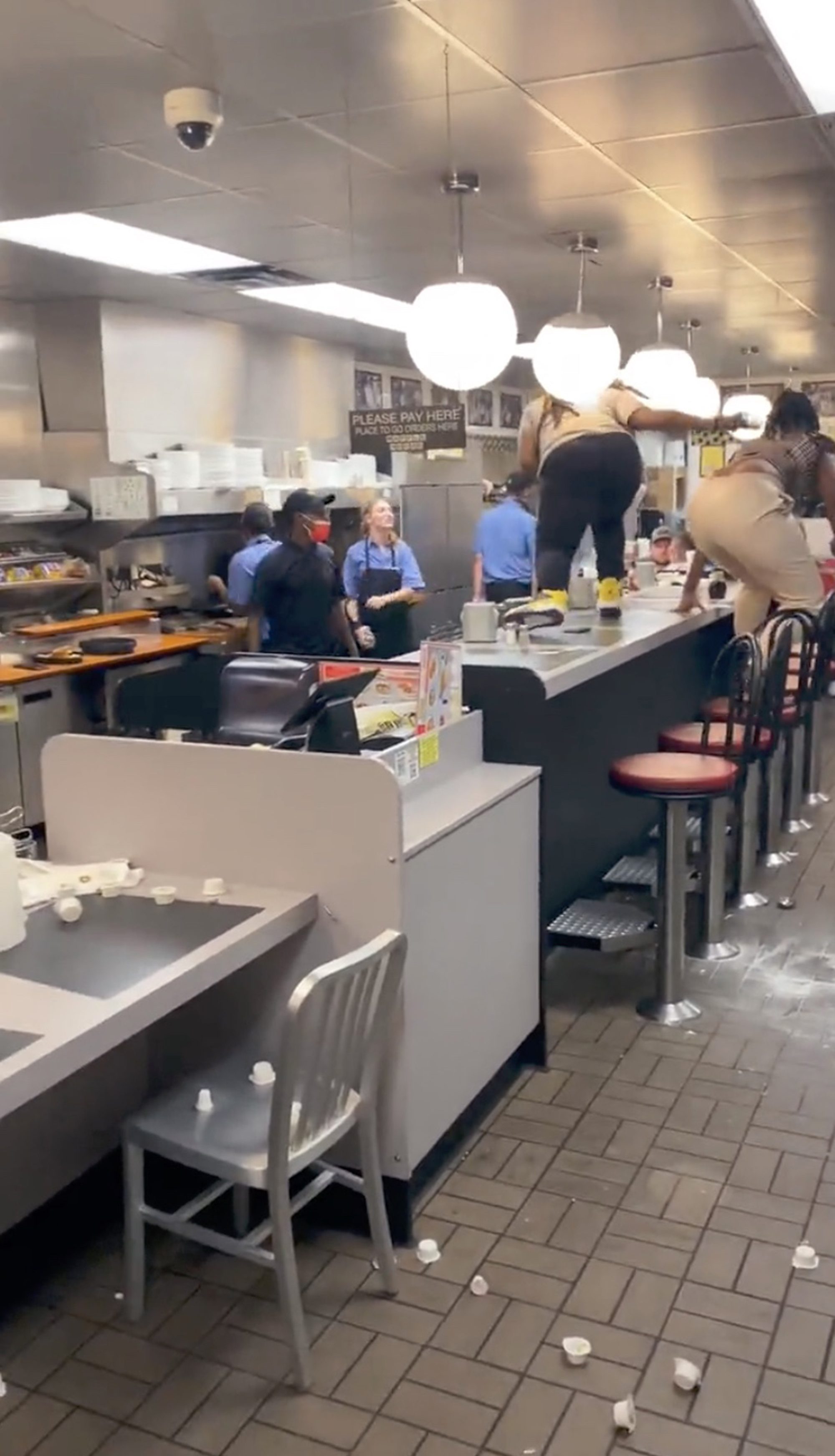 The viral clip shows several hungry patrons attacking employees after allegedly becoming upset by slow service. 
