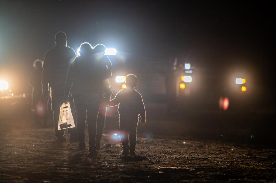 A migrant family walks to be processd by border patrol officers after crossing the Rio Grande into the U.S. on May 05, 2022 in Roma, Texas.