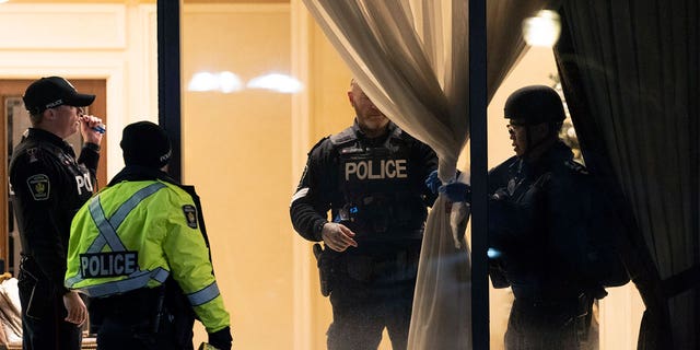 Police stand in the lobby of a condominium building following a shooting in Vaughan, Ontario.