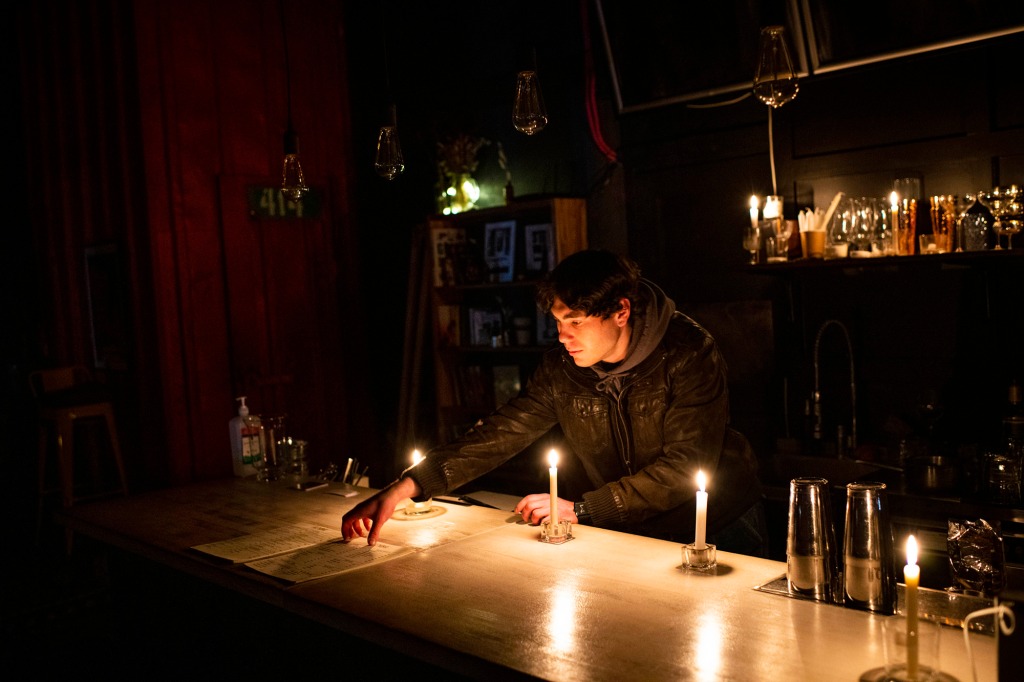 a man places a menu by candlelight