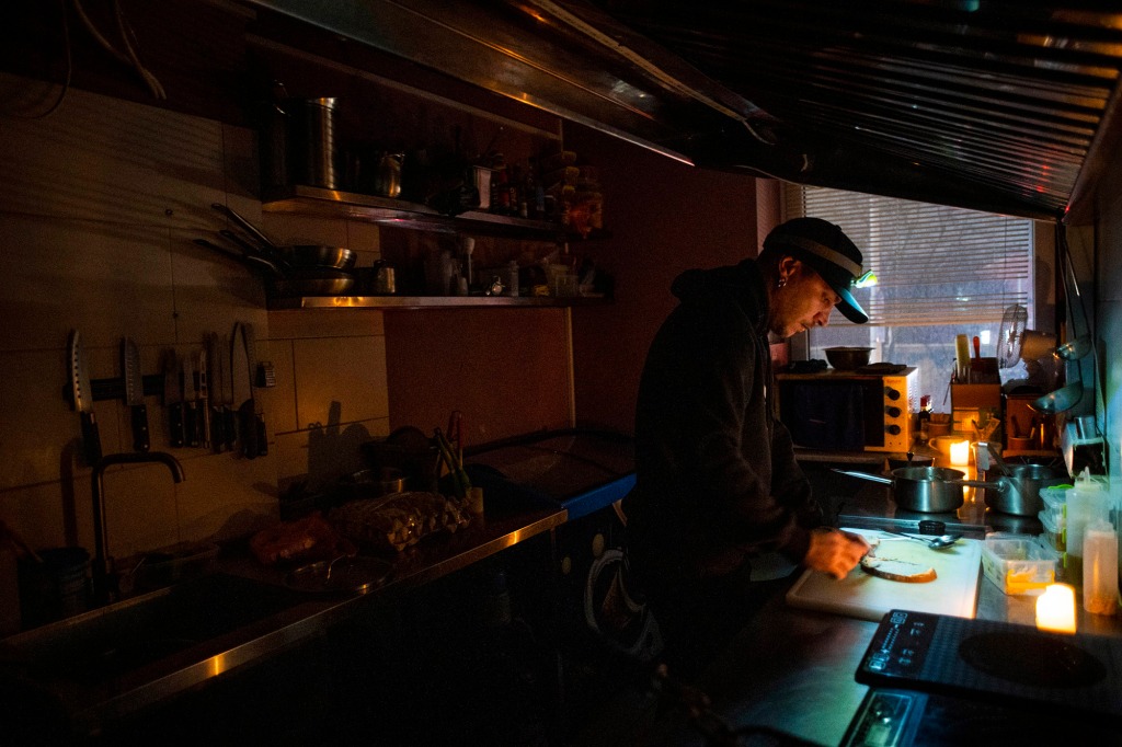 A man making food by dim light