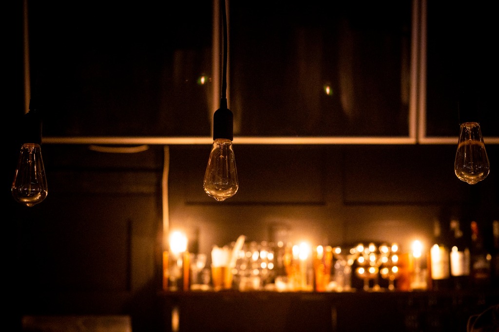 Lightbulbs hang dormant by candlelight