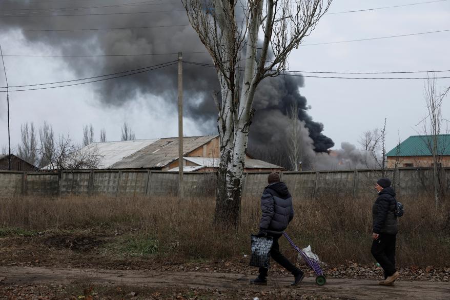 Volodymyr, 61, and Nataliia Bolias, 51, walk past an industrial building that received a missile strike, as Russia's attack on Ukraine continues, during intense shelling on Christmas Day at the frontline in Bakhmut, Ukraine, December 25.