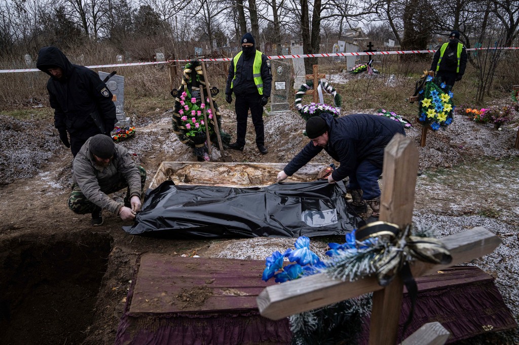 Funeral workers remove the body of a Ukrainian man killed by Russian forces on Dec. 5.