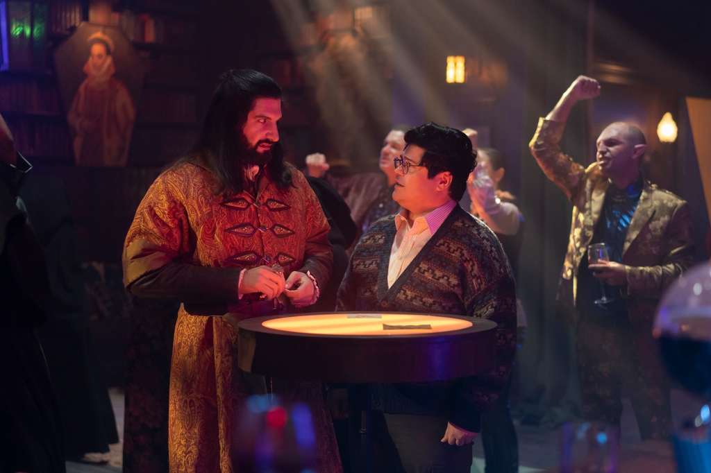 Nandor (Kayvon Novak, left) and Guillermo (Harvey Guillen) in "What We Do in the Shadows." They're in the vampire nightclub and Nandor is looking down at Guillermo, who's much shorter, with a disgusted look on his face.