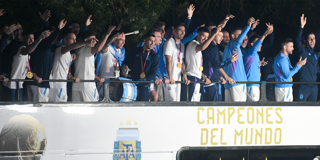 Players from the Argentina men's soccer team that won the World Cup wave at fans from a bus in Buenos Aires, Argentina.