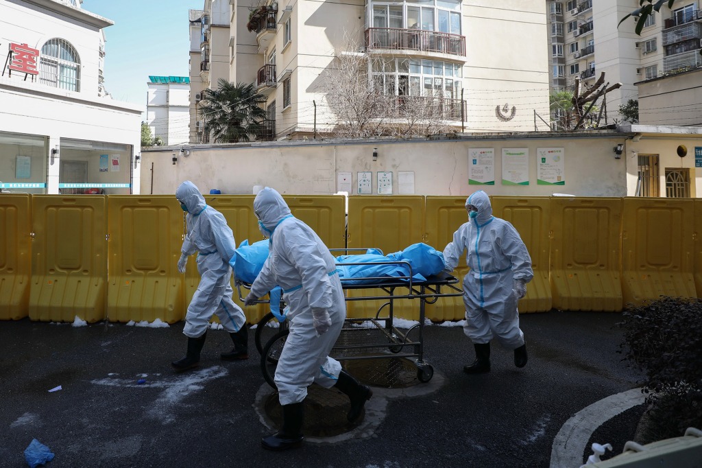 Workers move the body of a COVID-19 victim at a hospital in Wuhan, China on Feb. 16, 2020.