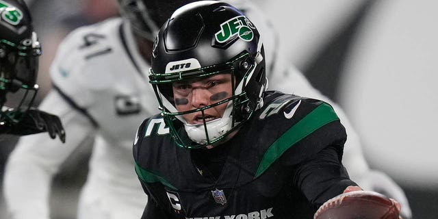 New York Jets quarterback Zach Wilson (2) hands off the ball to New York Jets running back Michael Carter (32) during the first quarter of an NFL football game against the Jacksonville Jaguars, Thursday, Dec. 22, 2022, in East Rutherford, N.J.