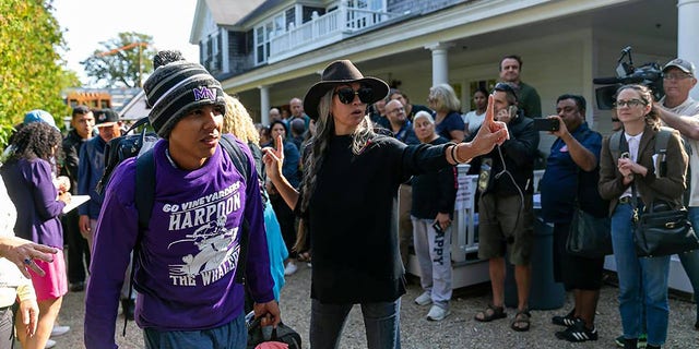 A Venezuelan migrant is led onto a bus at St. Andrews Episcopal Church on Friday, Sept. 16, 2022, in Edgartown, Massachusetts, on the island of Martha's Vineyard. A group of migrants was flown to the island from Texas. They are here being transferred to a Cape Cod military base. 