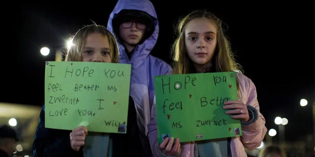 Willow Crawford, left, and her older sister Ava, right, join friend Kaylynn Vestre, center, in expressing their support for Richneck Elementary School first-grade teacher Abby Zwerner during a candlelight vigil in her honor at the School Administration Building in Newport News, Va., Monday, Jan. 9, 2023.