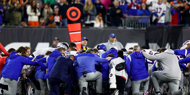 Buffalo Bills players and staff kneel together in solidarity after Damar Hamlin sustained an injury during the first quarter of an NFL football game against the Cincinnati Bengals on Jan. 2, 2023 in Cincinnati.