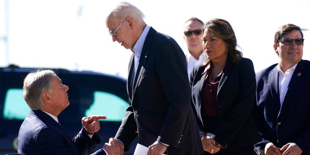 President Joe Biden, right, shakes hands with Texas Gov. Greg Abbott after Abbott handed him a letter about the border at El Paso International Airport in El Paso, Texas, Sunday, Jan. 8, 2023.