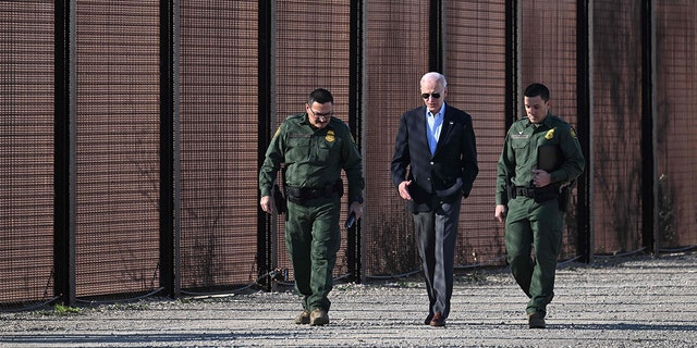 President Joe Biden speaks with a member of Border Patrol as they walk along the U.S.-Mexico border fence in El Paso, Texas,