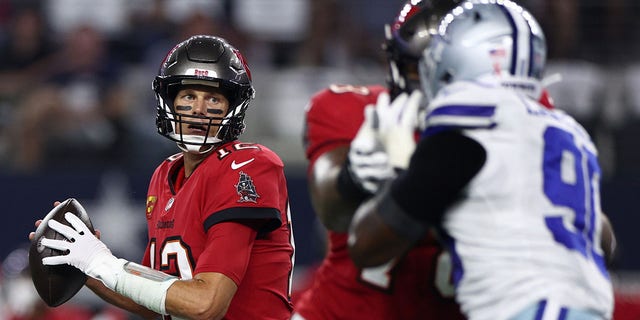 Tom Brady #12 of the Tampa Bay Buccaneers look to throw against the Dallas Cowboys during the first half at AT&amp;T Stadium on September 11, 2022 in Arlington, Texas.