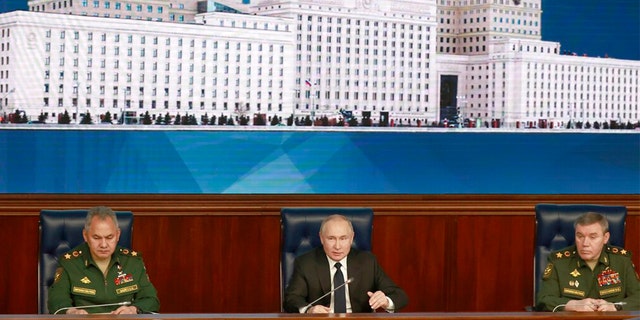 Russian President Vladimir Putin, center, speaks as Russian Defense Minister Sergei Shoigu, left, and Chief of the General Staff Gen. Valery Gerasimov attend a meeting with senior military officers in Moscow, Russia, Wednesday, Dec. 21, 2022. 