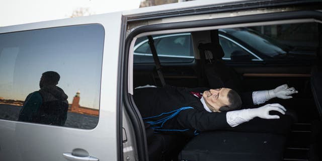 Andreas, 39-year-old, member of the Swedish solidarity committee for Rojava is reflected next to a car carrying an effigy of Turkish President Recep Tayyip Erdogan, on January 16, 2023, in Stockholm, Sweden. - Their action threw another spanner in the works of Sweden's efforts to join NATO and pro-Kurdish activists who hanged on January 11, 2023 an effigy of Turkey's president in Stockholm argue their "provocation" was in the name of free speech. (Photo by Jonathan NACKSTRAND / AFP) 