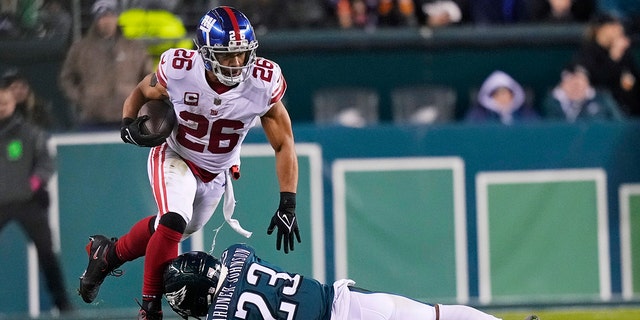 New York Giants running back Saquon Barkley, #26, runs with the ball as Philadelphia Eagles safety C.J. Gardner-Johnson, #23, tries to stop him during the second half of an NFL divisional round playoff football game, Saturday, Jan. 21, 2023, in Philadelphia.