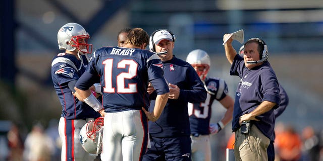 New England Patriots' Tom Brady (12), head coach Bill Belichick, far right, and offensive coordinator Bill O'Brien, middle, talk before a game at Gillette Stadium on Oct. 4, 2009.