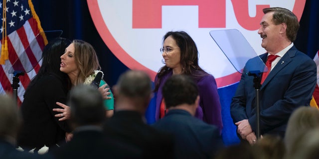 Re-elected Republican National Committee Chair Ronna McDaniel is hugged by a member as candidates Harmeet Dhillon and Mike Lindell look on at the committee's winter meeting in Dana Point, California, on Friday.