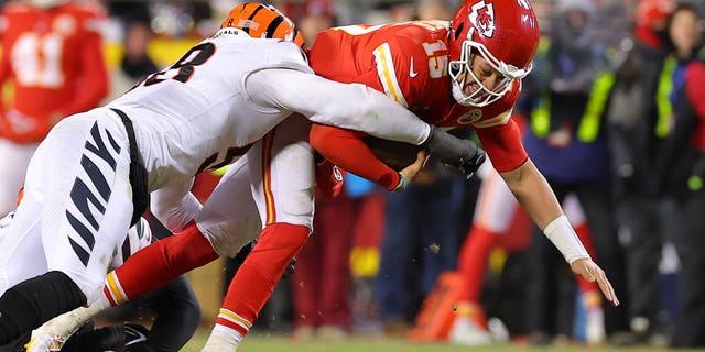 Joseph Ossai, #58, and Zach Carter, #95 of the Cincinnati Bengals, tackle Patrick Mahomes, #15 of the Kansas City Chiefs, during the fourth quarter in the AFC Championship Game at GEHA Field at Arrowhead Stadium on Jan. 29, 2023 in Kansas City, Missouri.