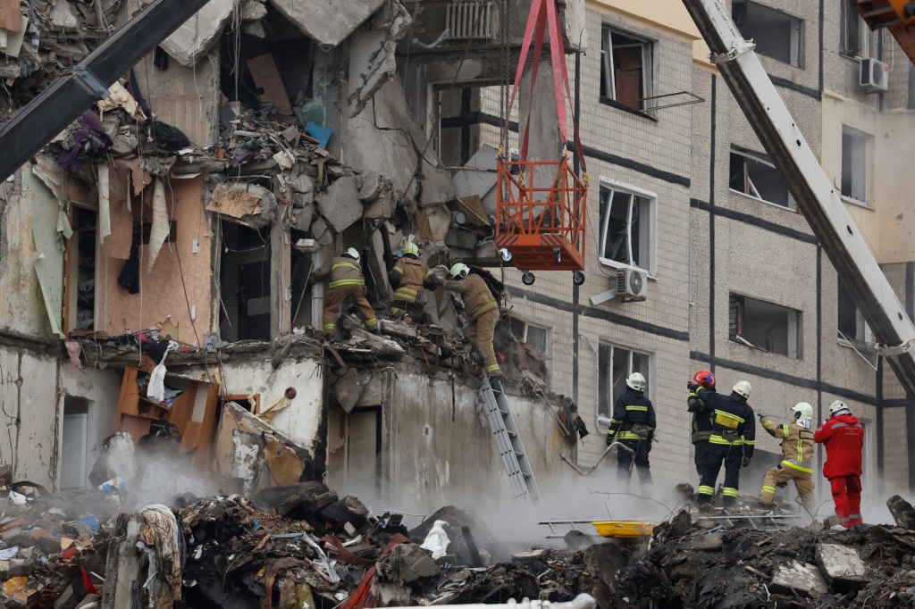 Rescue workers search for survivors in the damaged apartment building.