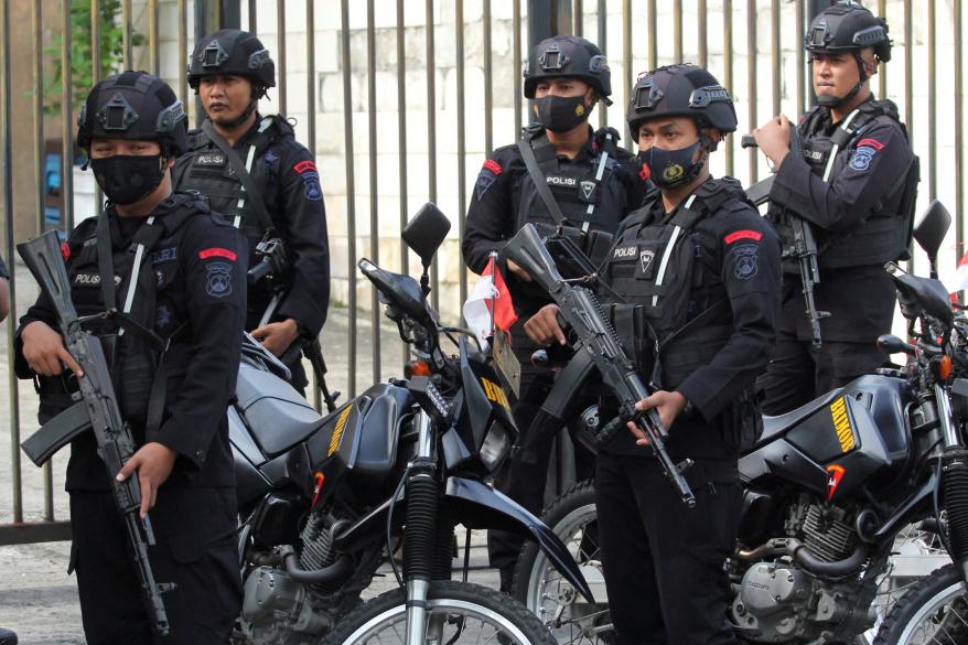 Mobile brigade police personnel stand guard outside the Surabaya court ahead of the first trial over a soccer stampede in Surabaya, East Java province, Indonesia, on Jan. 16, 2023