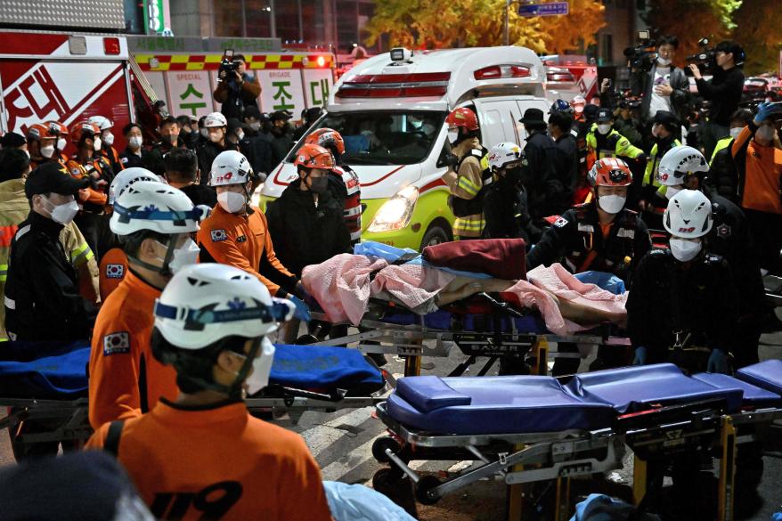 Medical staff transport a victim of a Halloween crush on a stretcher in the district of Itaewon in Seoul on Oct. 30, 2022.