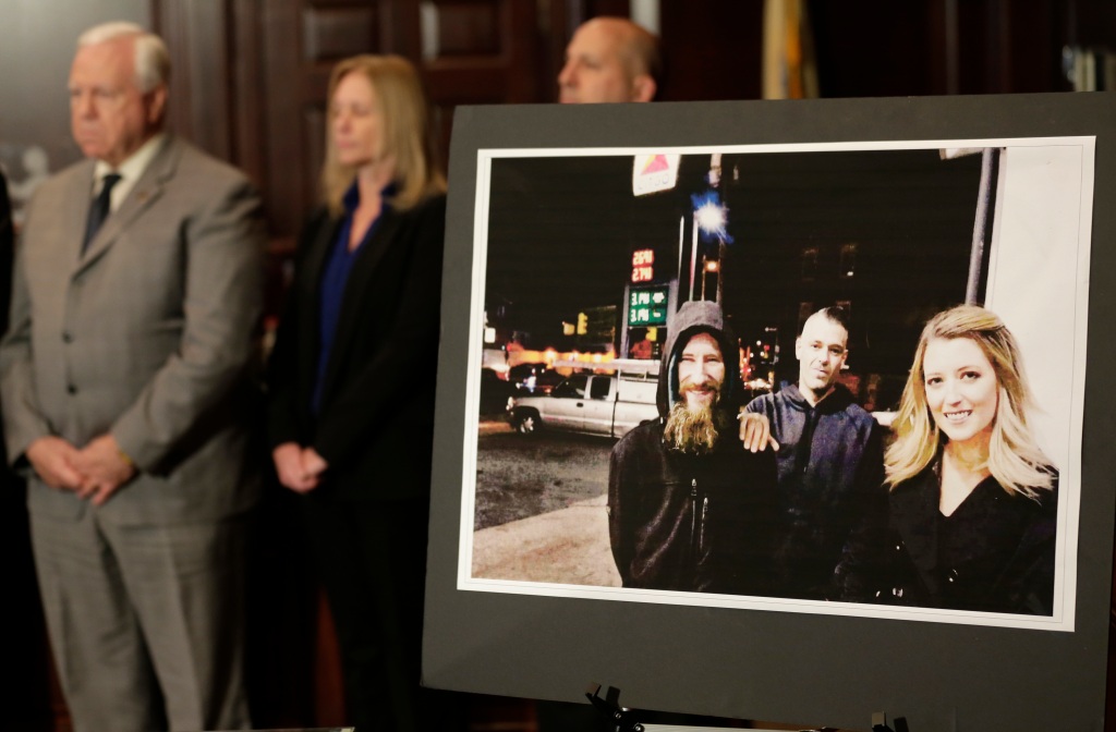 A picture of McClure, Mark D'Amico, and Johnny Bobbitt Jr. is displayed during a 2018 news conference about the scam.