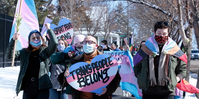 Advocates for transgender people march from the South Dakota governor's mansion to the capitol in Pierre, South Dakota, on March 11, 2021.