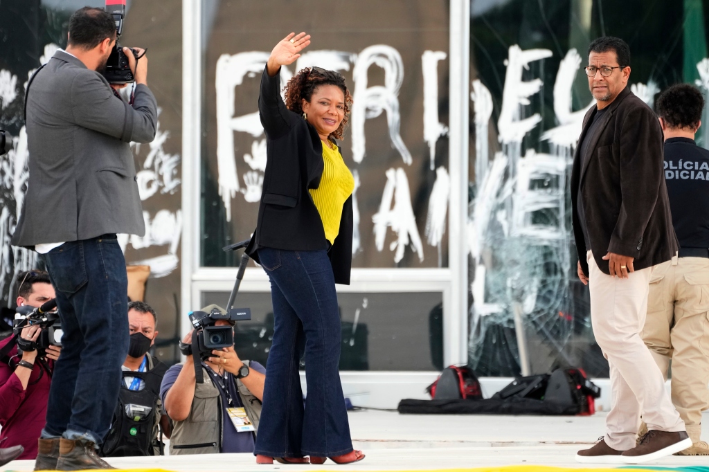 Culture Minister Margareth Menezes waves to the press after inspecting art pieces damaged by rioters.