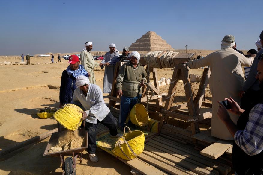 Egyptian antiquities workers dig at the site of the Step Pyramid.