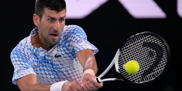 Novak Djokovic of Serbia plays a backhand return to Stefanos Tsitsipas of Greece during the men's singles final at the Australian Open tennis championship in Melbourne, Australia, Sunday, Jan. 29, 2023. 