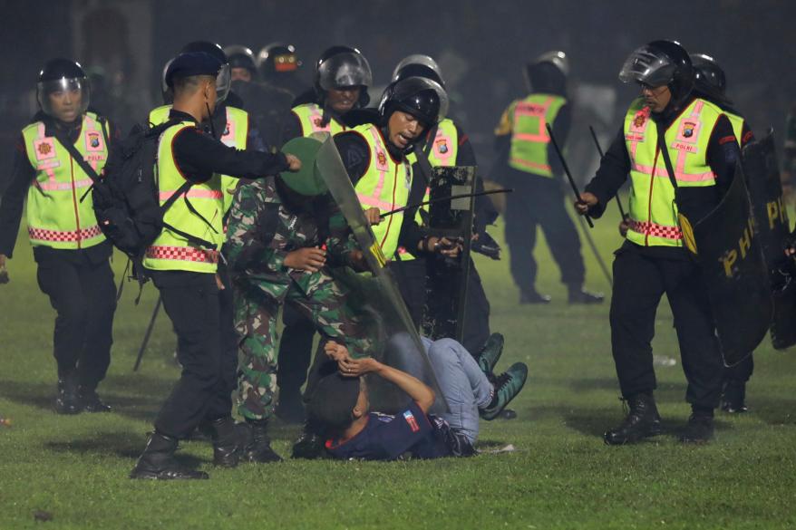 Security officers detain a fan during a clash between supporters of two Indonesian soccer teams at Kanjuruhan Stadium in Malang, East Java, Indonesia, on Oct. 1, 2022.