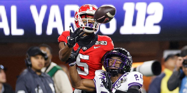 Adonai Mitchell #5 of the Georgia Bulldogs catches a touchdown pass late in the second quarter against Josh Newton #24 of the TCU Horned Frogs in the College Football National Championship game at SoFi Stadium on January 9, 2023, in Inglewood, California.