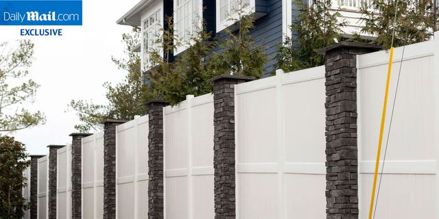 A white fence with stone columns around President Biden's vacation beach house in Delaware. President Biden has recently constructed a wall around his property.